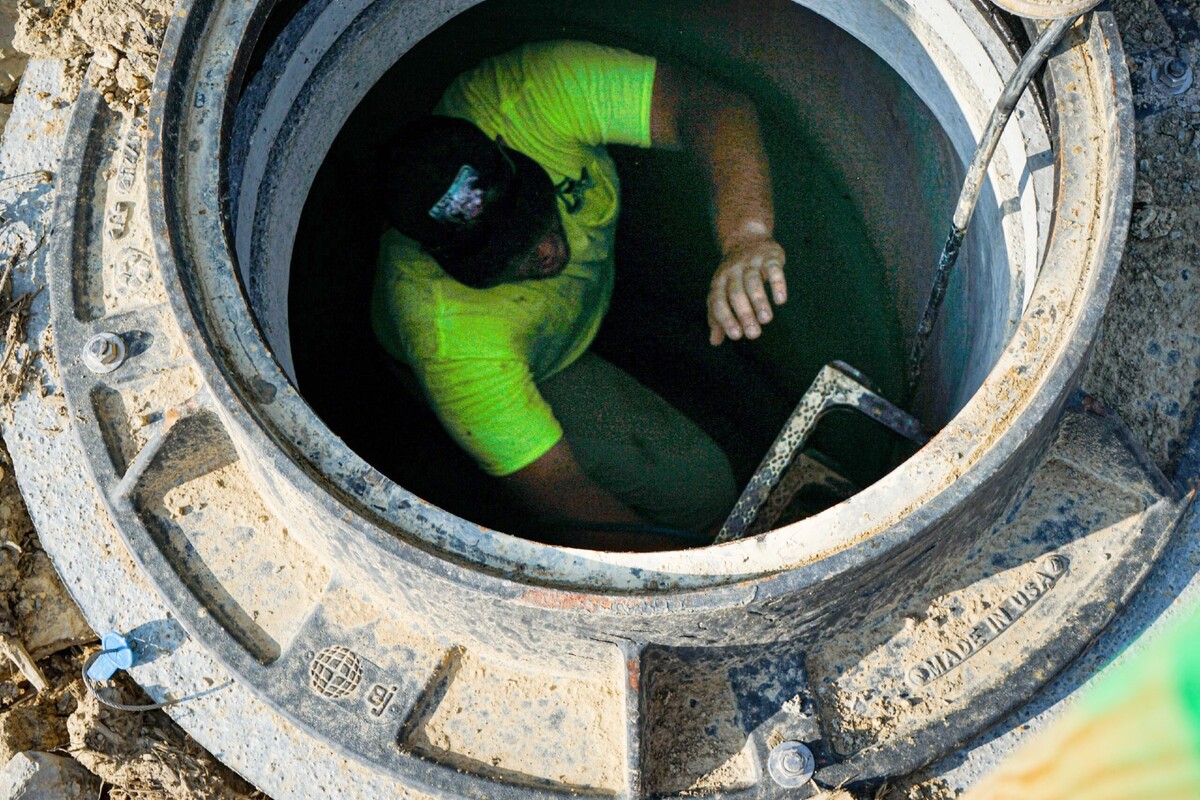 Man climbing down a hole